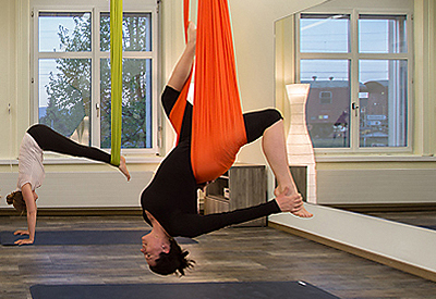 Frau im Aerial Yoga Tuch kopfüber hängend