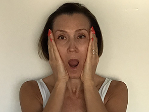 Frau mit geöffnetem Mund macht Face Yoga zum Dehnen der Gesichtsmuskeln